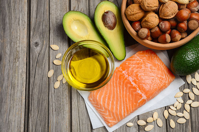Image of avocados, nuts, and fish, representing foods that contain healthy fats.