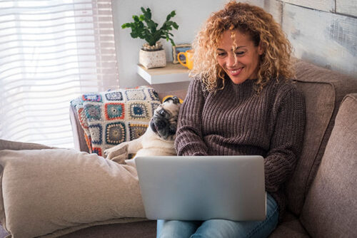 A person smiling while using their laptop.