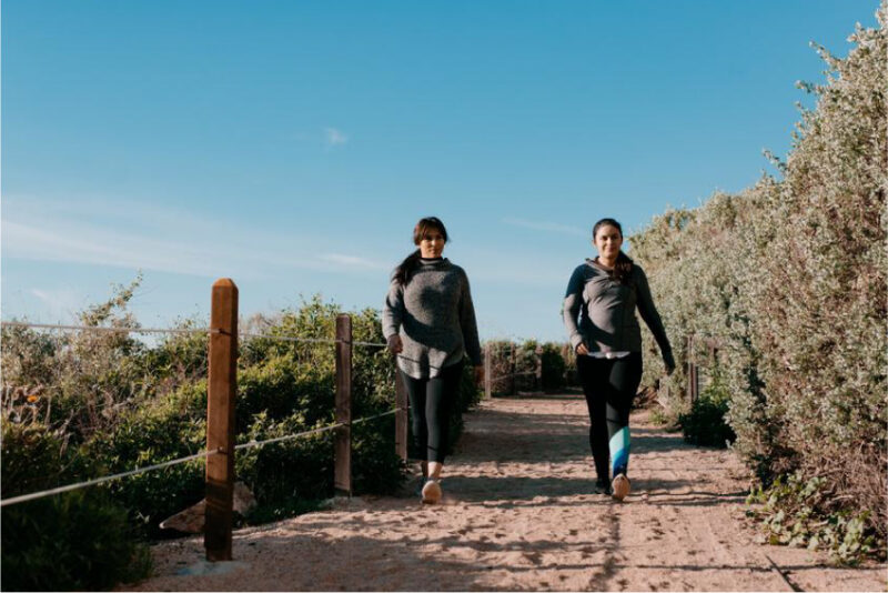 Two women running outside.