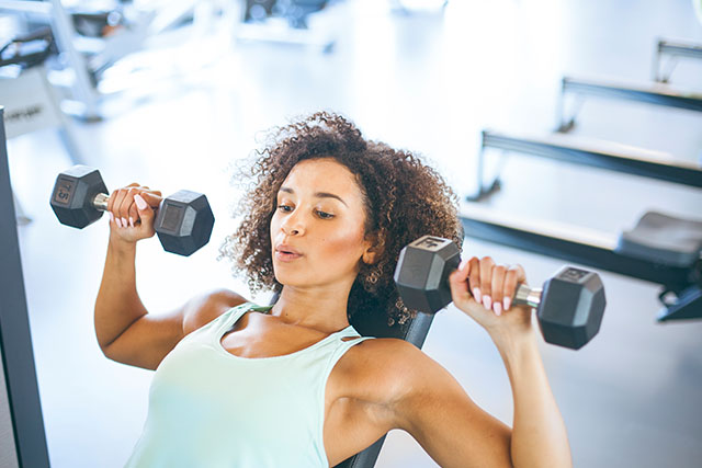 A woman lifting weights and practicing their strength training.
