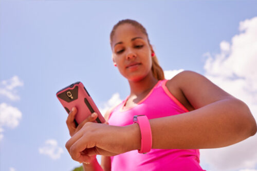 A person checking their watch while holding their phone.