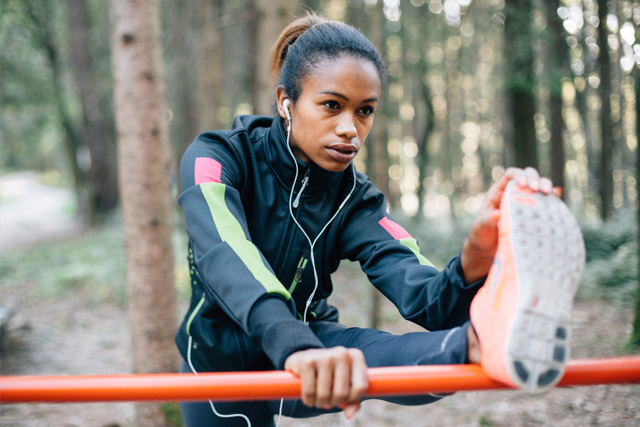 A person stretching in the middle of their run.