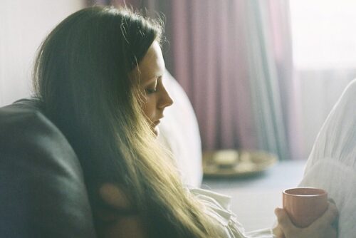 A woman looking down at her drink wondering whether there are signs of an unhealthy relationship with her partner.