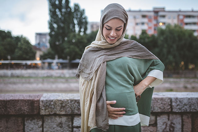 pregnant woman cradling stomach