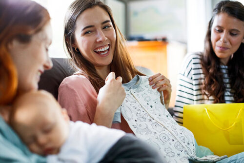 pregnant woman holding onesie