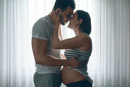 kissing pregnant couple