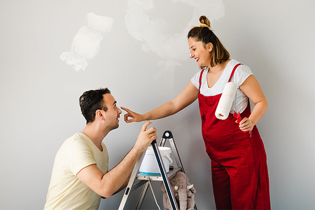 expecting couple painting wall