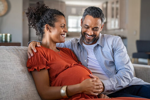 expecting couple sitting on couch