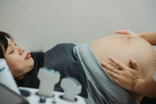 doctor checking pregnant woman's stomach