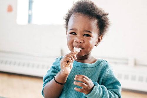toddler eating with spoon