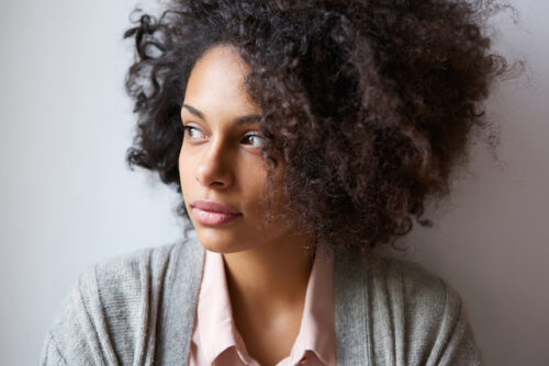 A person leaning against the wall and looking away.