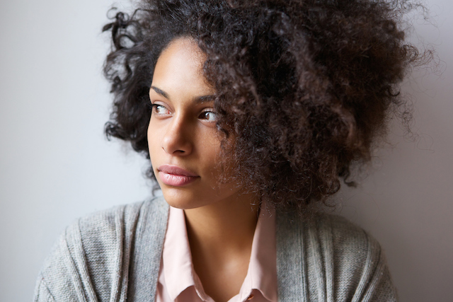 A person leaning against the wall and looking away.