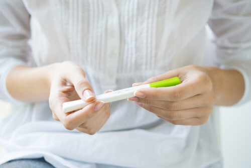 A person looking at their pregnancy test.