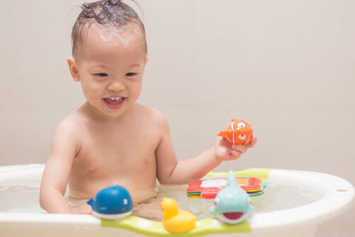 baby with toys in bathtub