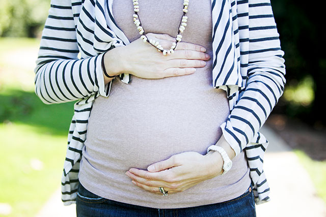 pregnant woman holding stomach