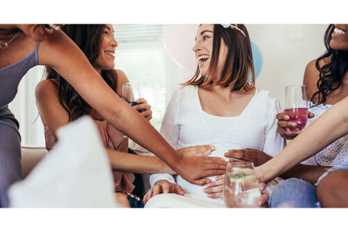 friends touching pregnant woman's stomach