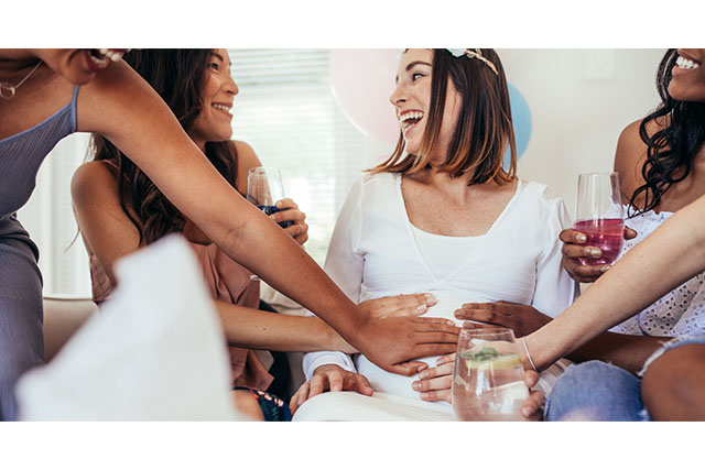 friends touching pregnant woman's stomach
