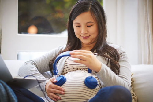 pregnant woman playing music for baby