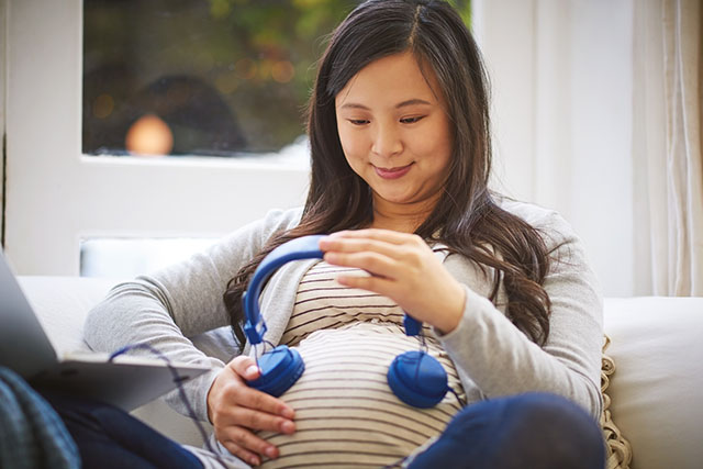 pregnant woman playing music for baby
