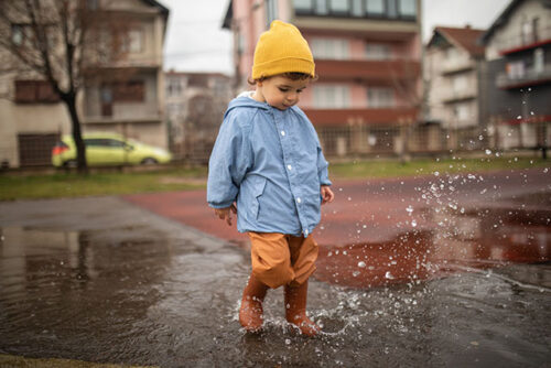 toddler playing in puddles