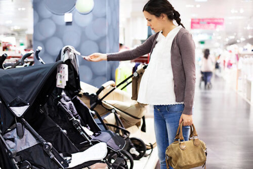 pregnant woman looking at strollers