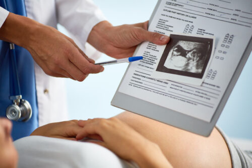 A pregnant person receiving an X-ray from their reproductive healthcare provider.