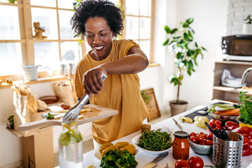Image of a woman making healthy snack alternative.