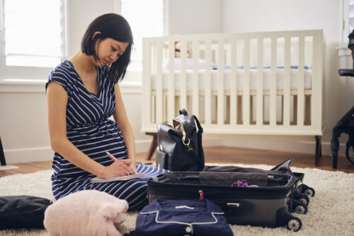 Woman in nursery packing hospital bag