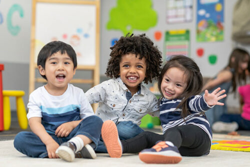 three toddlers smiling