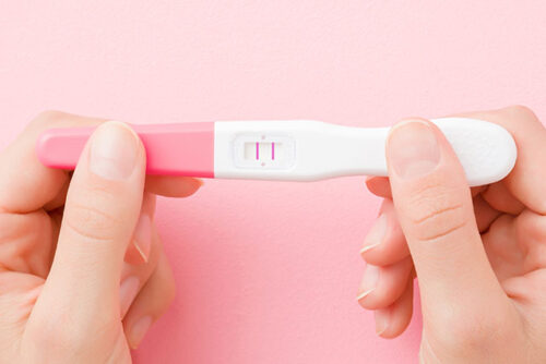 A person holding a pregnancy test.