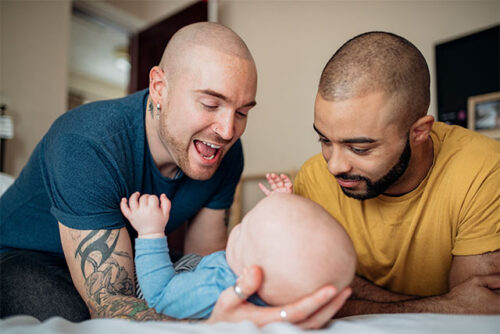 two fathers holding their baby