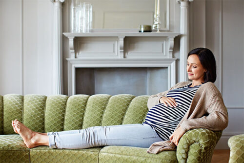 pregnant woman relaxing on couch