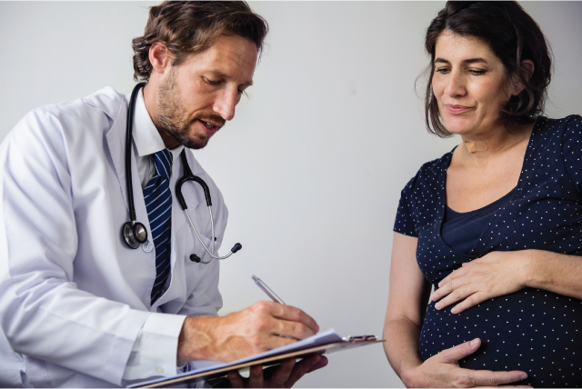 Pregnant woman speaking with doctor