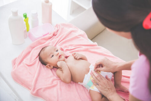A mother putting on a new diaper.