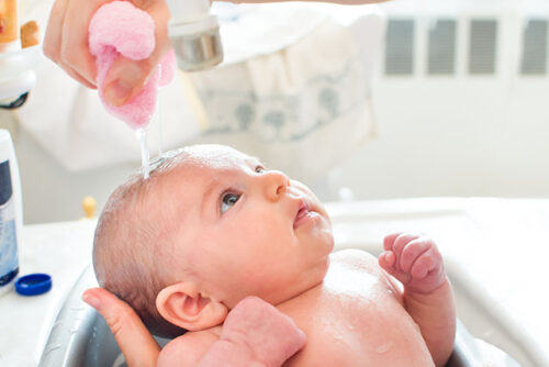 A baby getting bath.