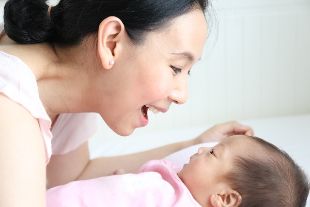 A person looking into their newborn baby's eyes to represent vision development the first few months after birth.