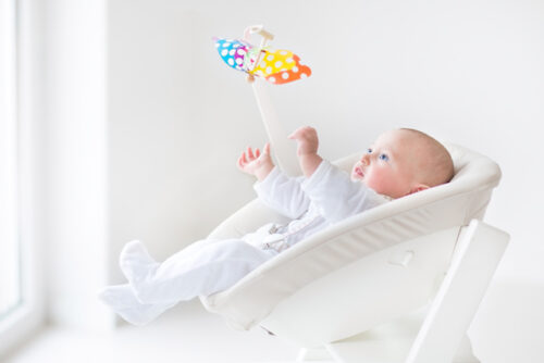A newborn playing with toys.