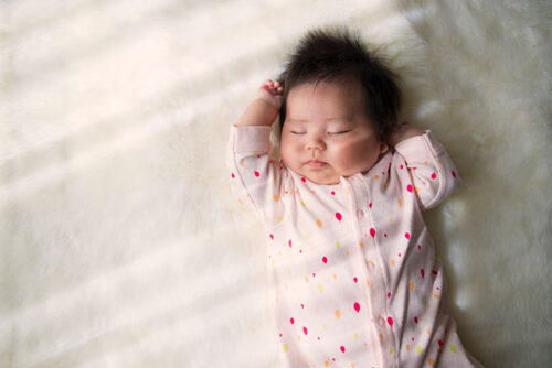 A baby sleeping on back.