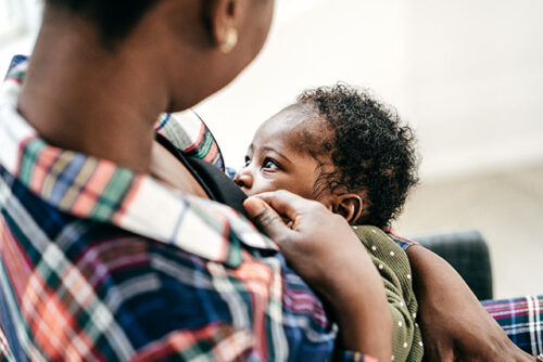 A person breastfeeding a newborn.