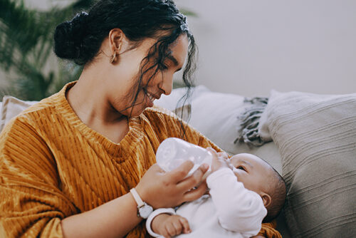A person bottle feeding their baby.