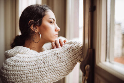 A person looking out a window and wondering how to manage depression