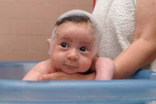 Someone washing their baby's hair.