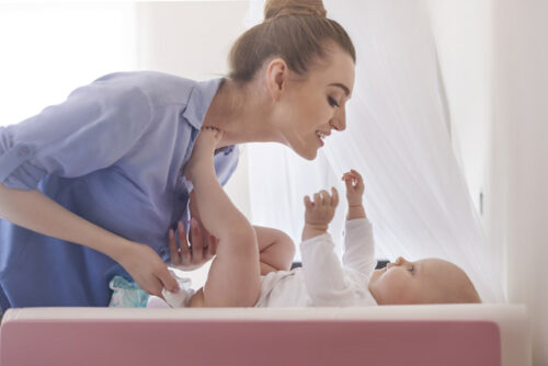 A babysitter playing with the baby.