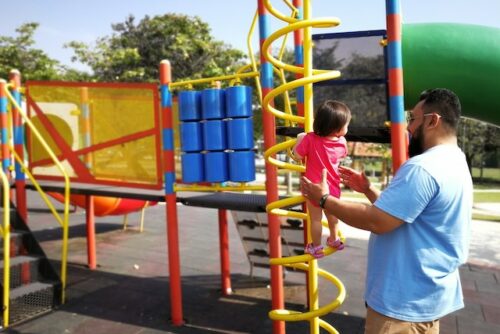 father with toddler daughter at the playground