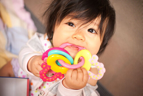 baby chewing on toys