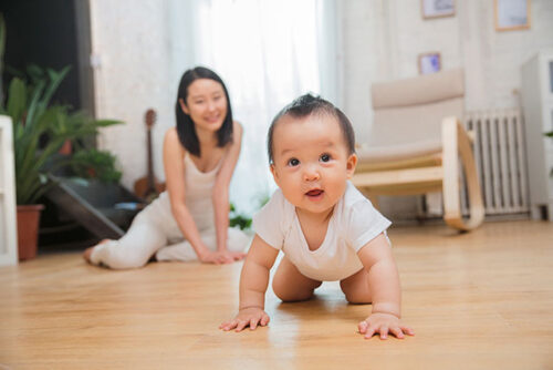 mom watching baby crawl