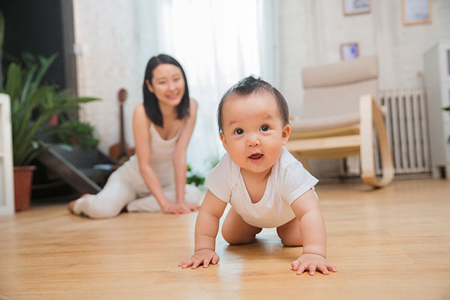 mom watching baby crawl