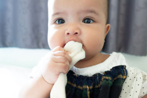 baby chewing on towel