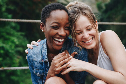 Two women smiling and sharing IVF success stories.