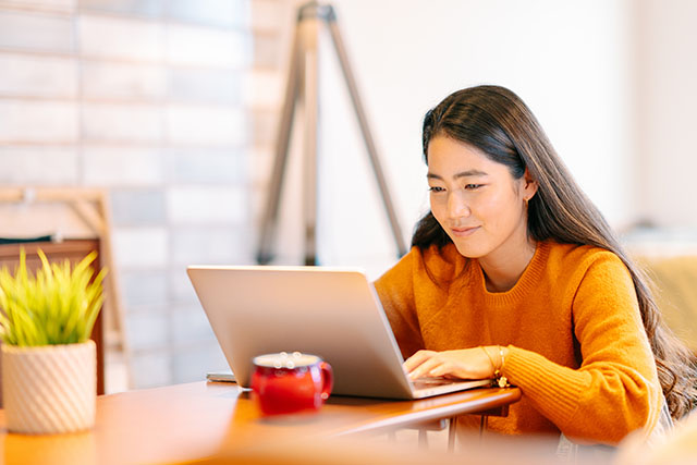 A person on their computer looking up quick stretching routines they can do at home.